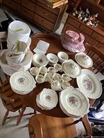 Overall view of all plates, bowls, cups, saucers and storage bags arranged on table