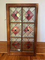 Full front view of wood-framed stained glass panel showing six floral sections