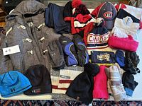 Wide view showing all the items: Joe Fresh grey coat, Osh Kosh splash pants, multiple toques, scarves, and gloves from brands like Under Armour and Roots
