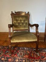 Front view of the East Lake antique chair showcasing detailed wood carvings and olive green velvet upholstery.