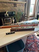 Four levels of varying lengths displayed on a table including two long levels, one medium wooden level, and one small black torpedo level.