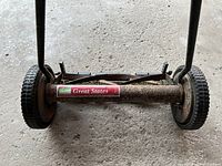 Close-up photo of the front side showing the Green States label and metal cylindrical blade assembly with large wheels on either side.