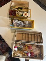 Overview of three containers on table showing assortment of fishing tackle including lures, hooks, floats, and lines