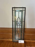 Front view of rectangular stained glass panel leaning against wall