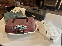 Five fishing tackle boxes arranged on a table, showing exterior top and side views