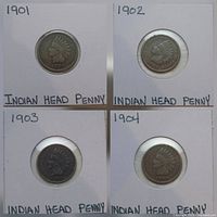 Four Indian Head pennies from 1901, 1902, 1903, and 1904 in protective sleeves with date labels