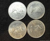 Four Canadian silver dollar coins heads side featuring Queen Elizabeth II portrait and date 1982.