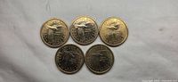 Five uncirculated 2000 Sacagawea dollar coins showing the reverse side with eagle design.