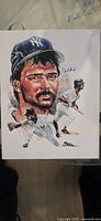 Front view full image of hand-signed Don Mattingly montage print by Ron Lewis, showing signature and various action illustrations.