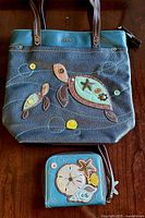 Full view of handbag and wallet showing appliqué sea turtle and ocean motifs with button accents