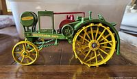 Side view of the green and yellow Waterloo Boy tractor model showing spoked wheels and detailed mechanical components.