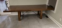 Rustic modern style wooden dining table assembled with no leaves extended, showing clean lines and rich finish.
