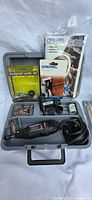 Overview of Dremel rotary tool in gray carrying case with various accessories, diamond wheel set, manuals, wrench, and attachments.