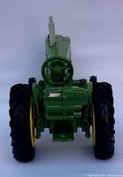 Front view of the green and yellow John Deere diecast tractor showing steering wheel and front tires.