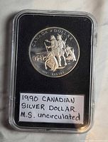 Front of the silver dollar showing the Kelsey Expedition design with explorers and inscription 1990 Kelsey 1690 Canada Dollar.