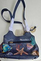 Front view of Anuschka hand painted genuine leather purse showing the detailed Mystical Reef design, zipper pocket, and signature on the front.