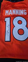 Close-up photo of back jersey showing "MANNING" name patch, number 18 and autograph on number 1.