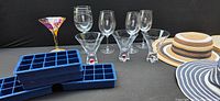 Shows all items in the lot including martini glasses with red swirl bases, wine glasses, ice cube trays, and sunhats.