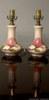 Front view of both lamps showing matching shape, color, and painted magnolia design