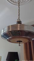 Full view of chrome pendant light hanging from ceiling medallion