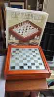 Photo of the wooden case with mirrored chess board and original box behind it