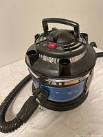 Front angle view showing body, handle, hose, and main power button of the vacuum