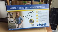 Box of M-Rail Home Bed Assist Handle featuring a woman using the product beside a bed and listing key benefits.