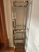 Full view of the tall, narrow 5-tier display shelf with polished chrome frame and clear glass shelves.