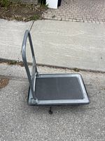 Side view of platform cart showing black platform and grey handle frame.