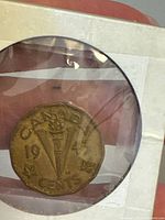 Reverse side showing torch with maple leaves and date 1943 in plastic holder.