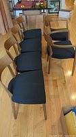 Full set of six chairs arranged on hardwood floor showing two armchairs and four side chairs