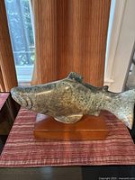 Full side profile of soapstone salmon sculpture on wooden base