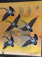 Close-up of flying geese, portrait silhouette and sun motif on orange background