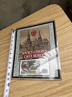 Front side of the commemorative display showing Soviet architecture artwork and a 1000 ruble bank note replica with 'Soviet Union's Last Ruble' title.