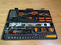 Open tool case showing arranged tools including wrenches, pliers, screwdriver with bits, socket set, level and tape measure