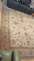 Full view of the large wool area rug showing intricate floral and vine pattern with a border in neutral earth tones