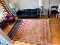 Full view of rug laid on hardwood floor beneath sofa and lamps