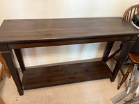Front view of wooden stained pine buffet table showing top surface and lower shelf