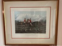 Front view of a framed print showing fox hunters on horseback with a hunting hound in the foreground, titled 'THE COUPLE AND HUNTING HOUNDS'