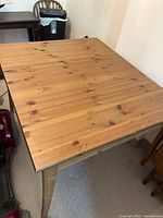 Full view of rectangular pine wood table with natural wood grain and knots.