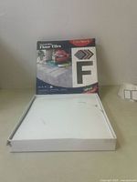 Box of FunStick peel and stick floor tiles with 30 tiles, visible square tile with stone-patterned surface shown