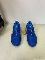 Front view of new blue ASICS men's running shoes with laces tied.