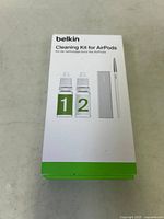 Front view of unopened Belkin Cleaning Kit for AirPods box showing labeled cleaning solutions, brush and cloth illustration.