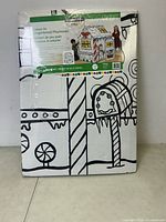 Photo of the sealed boxed colour-in gingerbread playhouse showing the front with black and white candy cane and gingerbread themed designs.