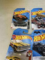 Top view showing four Hot Wheels cars in blister packaging, details include Ford GT-40 and Shark Bite.