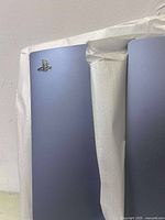 Blue PlayStation 5 console side covers, new in box, one panel has PlayStation logo, in partial protective wrapping.