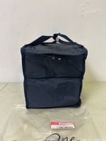 Front view of navy blue soft cooler with handles and zippered top.