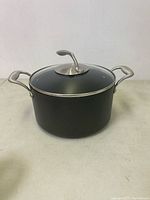 Front view of the black Tupperware pot with glass lid showing handles and lid handle