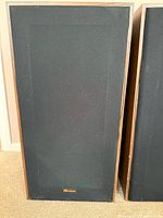 Speaker with grille in place showing external appearance and logo