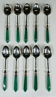 Full set of ten jade-handled silver-plated spoons laid out, handles pointing downward